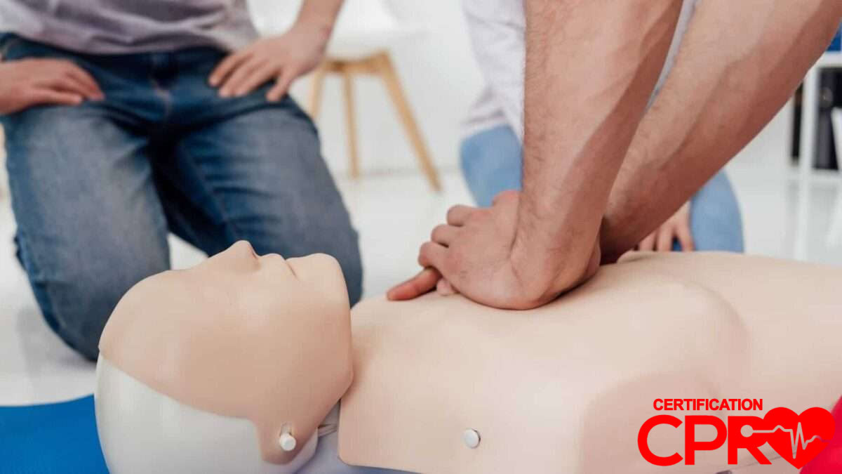 CPR training session with a man practicing on a mannequin in Laredo.